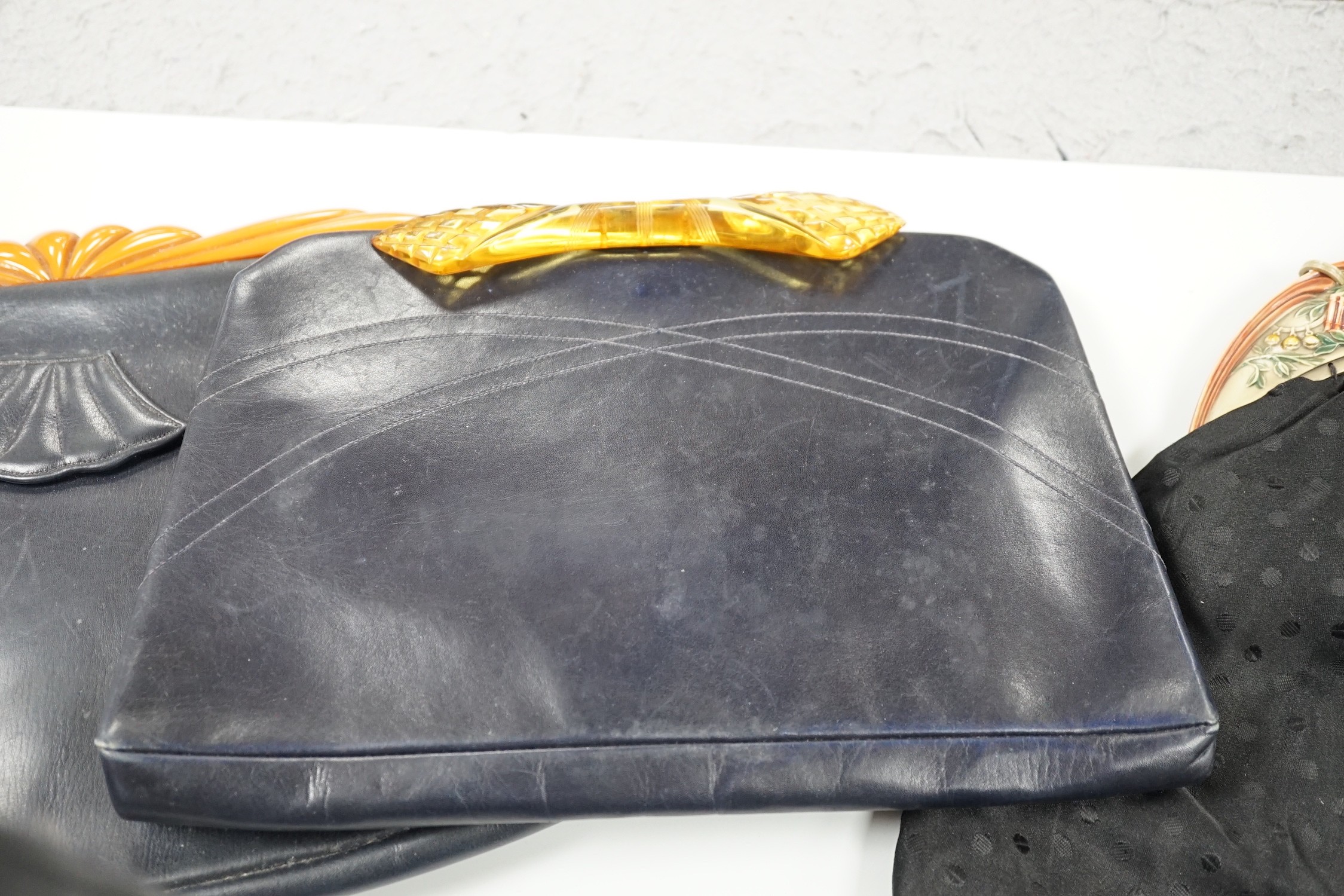 A 1930's Pierrot bakelite bag frame, together with three 1930's yellow bakelite and leather clutch bags (4)